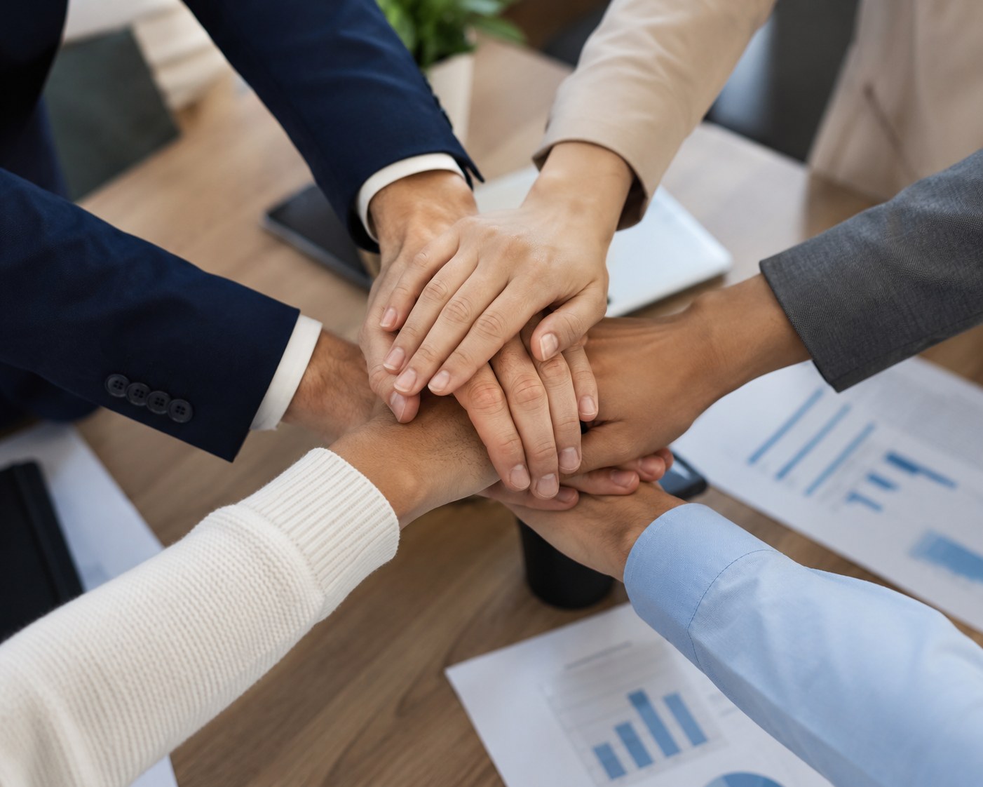 Business team hands stacked together in an office — Spyglass Investigations team